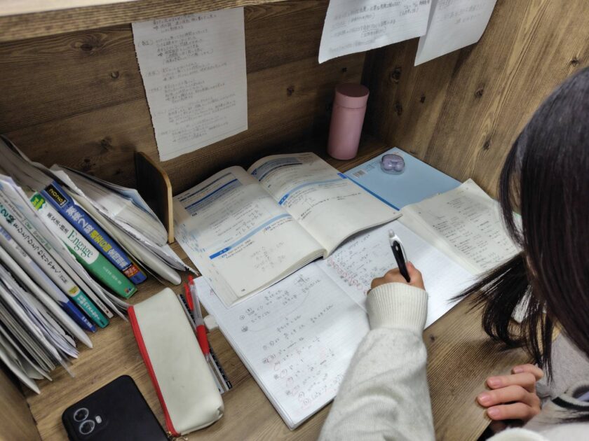 ノートに向かって手を動かす中学生の手元