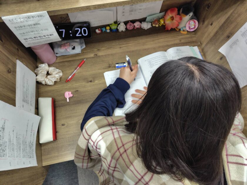 机に向かったまま手が止まっている中学生